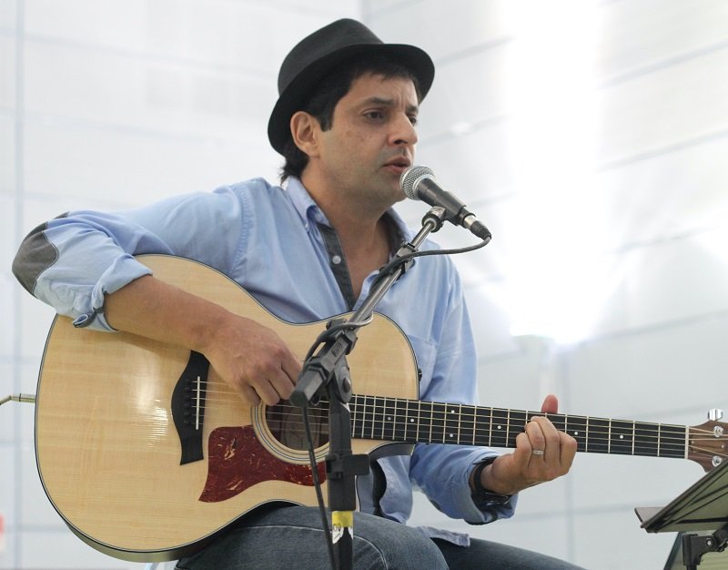 Foto do cantor e instrumentista Flávio Adonis tocando violão. 